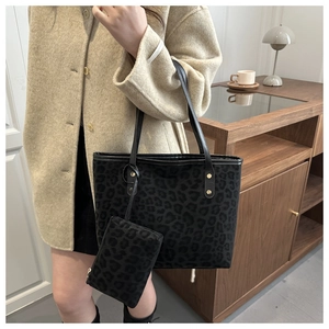 Detail of leopard print tote bag with small matching pouch and gold rivet accents