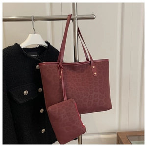 Detail of burgundy leopard print tote bag set with matching pouch and gold rivet accents