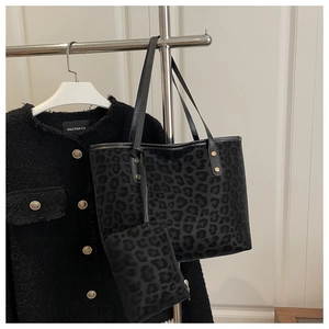 Close-up of leopard print tote bag and matching pouch on a hanger with a jacket