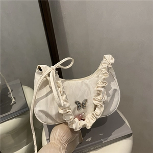 Chic creamy white underarm bag with butterfly metal charm and ruffled edges