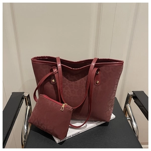 Close-up of wine red leopard pattern tote bag with matching pouch and gold hardware