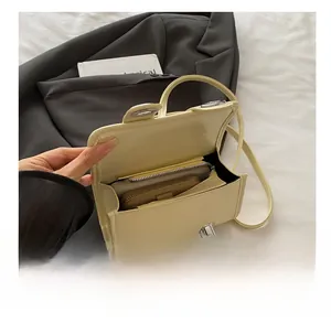 Vue intérieure montrant la capacité du sac bandoulière crème avec fermoir en métal