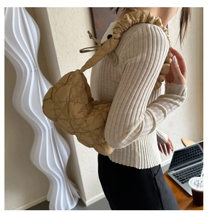 Detail of khaki quilted puffer bag with a stylish scrunchie strap and bow drawstring decor