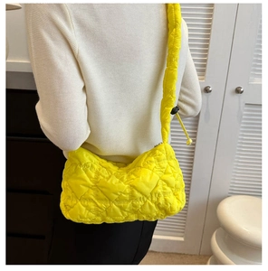 Detail of quilted puffy cloud bag in bright yellow with adjustable drawstring strap