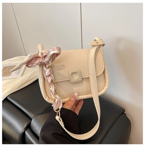 Beige mini square bag featuring a silk scarf wrapped chain handle and metal buckle detail