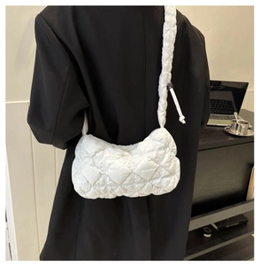 White quilted puffer shoulder bag styled on a black blazer for a modern aesthetic look