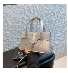 Detailansicht der silbernen Strass-Handtasche mit goldenem Drehverschluss und Griffen