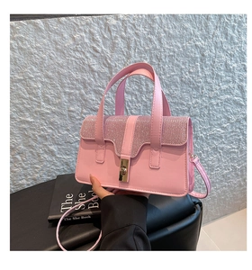 Detail der pinkfarbenen PU-Leder-Handtasche mit silbernen Strasssteinen und Goldschloss