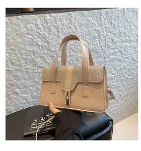 Detail der beigen Handtasche mit champagnergoldenen Pailletten und Drehverschluss