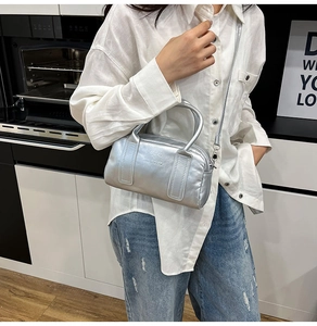 Detail of silver metallic Boston bag with embossed logo and dual top handles