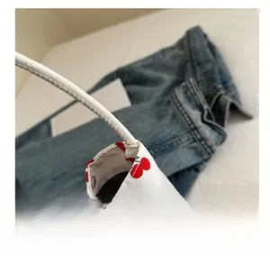 Close-up of white bucket bag with cherry prints and refined stitching details