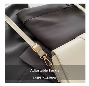 Detail of adjustable strap with gold-tone hardware on a creamy beige leather bag