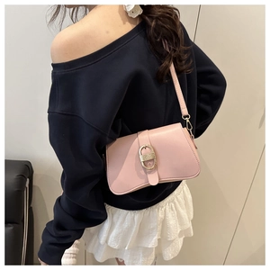 Detail view of pink shoulder bag with gold buckle on model for a trendy summer style