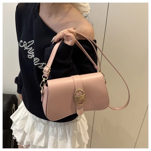 Détail du sac sous le bras en cuir rose mat avec boucle dorée en D et bandoulière