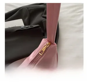 Detail of pink shoulder bag showing smooth golden metal zipper and high-quality faux leather