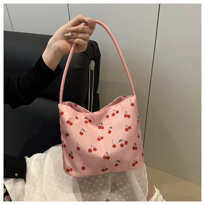 Detail of pink tote bag with cherry patterns showing the smooth texture and handle