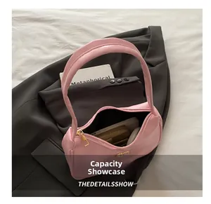 Pink underarm bag capacity display showing phone and wallet on grey blazer
