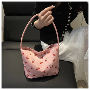 Close-up of pink tote bag featuring a vibrant red cherry print with single handle design