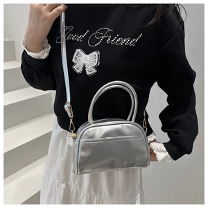 Detailansicht der silbernen Metallic-Minibag mit Reißverschluss und Doppelgriff-Design