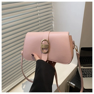 Detail of light pink shoulder bag featuring a gold D-ring buckle and matte texture