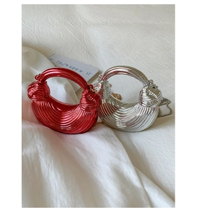 Detail of red and silver metallic pleated dumpling bags with twisted handle and chain strap