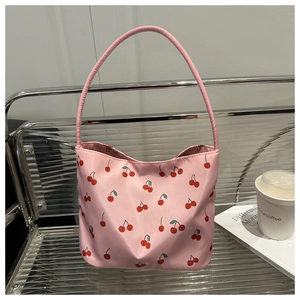 Pink tote bag with cherry print on a stylish metal chair in a modern cafe setting