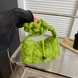 Quilted green puffy handbag with pleated handle and drawstring detail for daily use