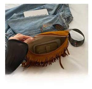 Sac bandoulière en daim marron avec franges montrant sa capacité pour téléphone et portefeuille
