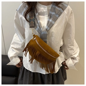 Détail du sac à franges en daim marron avec bandoulière tissée ethnique et métal doré