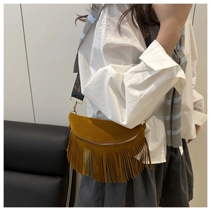 Detail of vintage fringe half-moon bag featuring ethnic-style jacquard shoulder strap