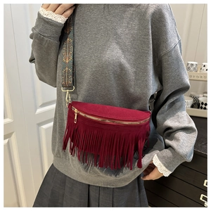 Détail du sac à bandoulière en daim bordeaux avec franges et sangle ethnique
