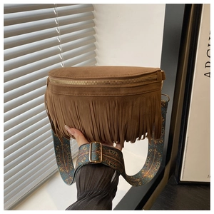 Detailed close-up of brown suede fringe bag with ethnic patterned wide strap and zipper