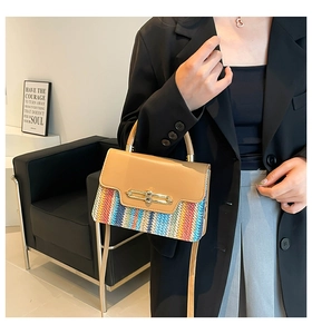 Detail of colorful woven straw pattern and smooth leather flap with metal lock buckle