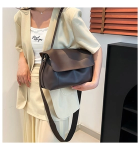 Detailed view of the dark brown leather tote bag with a smooth finish and metallic side buckle