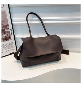 Detail of a dark brown PU leather tote bag with a matte finish on a minimalist white stand