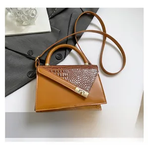 Detail of vintage brown tote featuring embossed crocodile pattern and gold metal clasp
