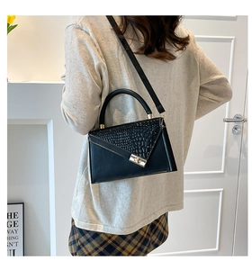 Chic black crocodile embossed leather crossbody bag shown on model in modern room