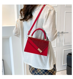 Detailed view of red crocodile pattern patchwork handbag with gold metallic twist lock