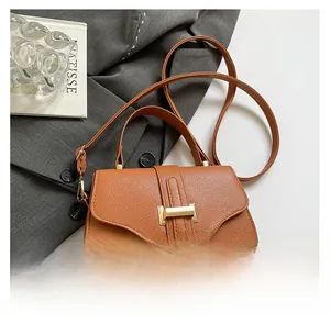 Close-up of brown litchi pattern PU leather handbag with golden H-shaped metal buckle
