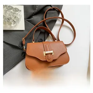 Detail shot of vintage brown satchel with gold buckle and lychee leather texture