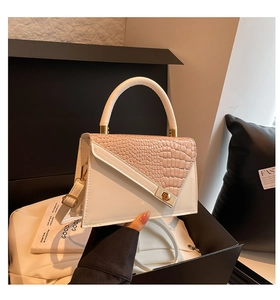 Detail of pink crocodile embossed leather flap bag with gold hardware in box