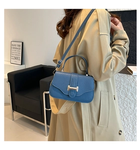 Blue lychee texture square bag with gold buckle on trench coat model outdoors