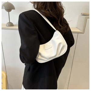 Dettaglio borsa baguette bianca a pieghe con logo in metallo su modella in blazer