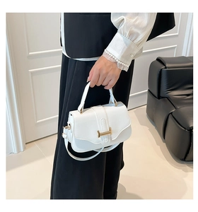 Detailed shot of white lychee leather square bag with elegant gold hardware and strap
