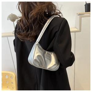 Dettaglio della borsa baguette argento metallizzato con texture plissettata e logo