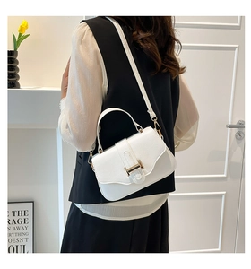 Close-up of white crossbody bag with gold H-clasp and litchi texture leather detail