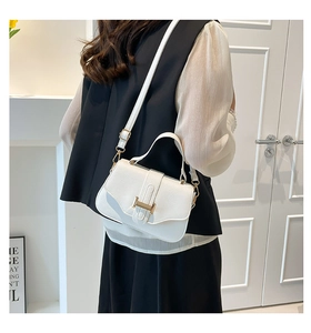 Detail of white litchi pattern leather bag with golden H buckle and top handle