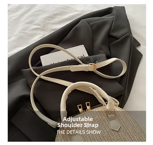 Detalle de bolso de paja tipo concha beige con correa de cuero y herrajes dorados