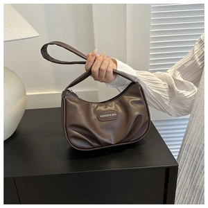 Dettaglio di una borsa sottobraccio arricciata marrone con etichetta Fashion & Bag