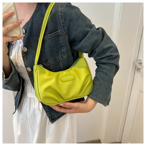 Dettaglio della borsa a mezzaluna verde neon con pieghe e targhetta fashion bag